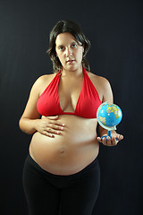 Image showing beautiful Pregnant woman with beautiful belly holding a world gl