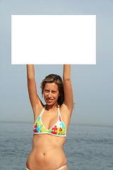 Image showing A gorgeous model holding a blank sign in the air