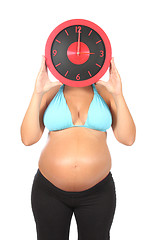 Image showing beautiful pregnant woman holding clock in hands