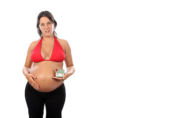 Image showing young pregnant woman holding house model over white background 