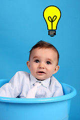 Image showing baby on a blue bucket having idea, studio shoot
