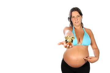 Image showing beautiful young pregnant woman holding a pig moneybox