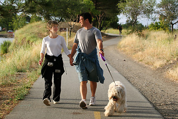 Image showing Couple walking their dog