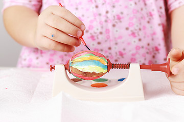 Image showing Child painting Easter eggs