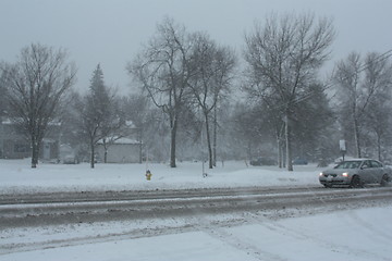 Image showing Picture taken during a winter storm that passed by the city - car slows down because of the snow and sleet on the busy street