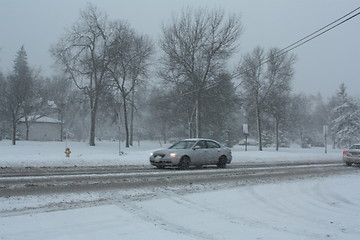 Image showing Picture taken during a winter storm that passed by the city - cars slow because of the snow and sleet on the busy street