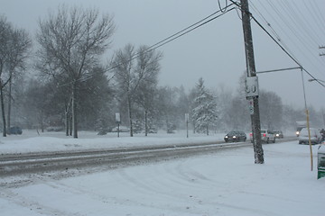 Image showing Picture taken during a winter storm that passed by the city - cars and trucks slow because of the snow and sleet on the busy street