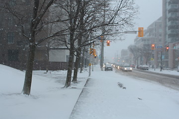 Image showing Picture taken during a winter storm that passed by the city - cars waiting, red traffic light 