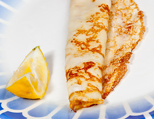 Image showing Pancake with lemon on blue plate