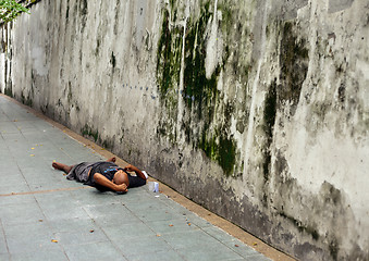 Image showing Homeless Man bundled sleep in a city doorway