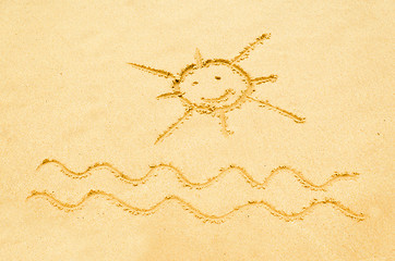 Image showing Smiling sun drawn on a sandy beach