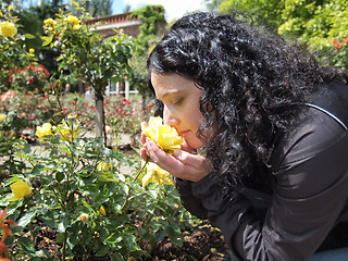 Image showing Pretty brunette smelling roses