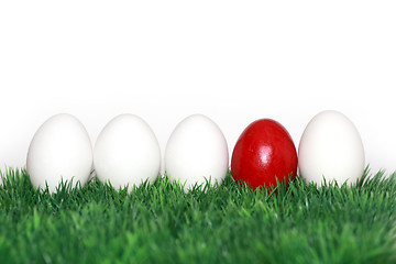 Image showing A red egg in between the white