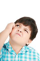 Image showing boy looking up and scratches his head, isolated on white