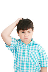 Image showing Boy scratches his head in puzzlement or confusion, as if ponderi