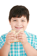 Image showing Little boy eating a integral bread, sandwich. isolated on a whit