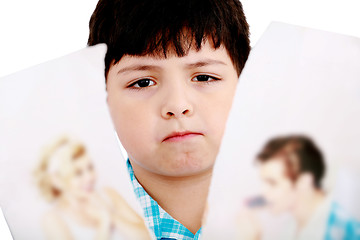 Image showing Upset boy standing in front pcture of parents with problems agai