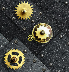 Image showing Gold gears against ferrous metal