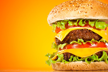 Image showing Tasty and appetizing hamburger on a yellow