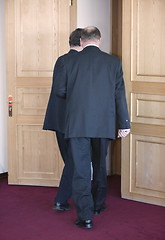 Image showing 2 men in suits  are leaving cabinet.