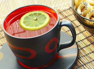 Image showing Cup of tea with a lemon on a table 