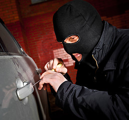 Image showing robber and the thief in a mask hijacks the car