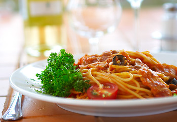 Image showing Spaghetti with a tomato sauce on a table in cafe