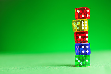 Image showing multicolored dices on green cloth