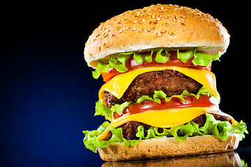 Image showing Tasty and appetizing hamburger on a dark blue