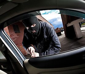 Image showing robber and the thief in a mask hijacks the car