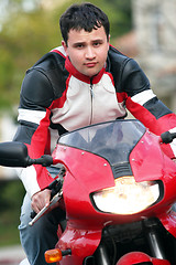 Image showing Man riding a red bike