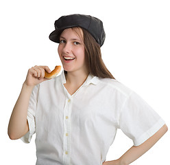 Image showing Portrait of a naughty girl in a cap with a bagel in his hand