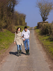 Image showing Couple of young people walking in the campaign in spring