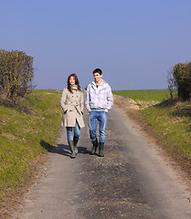 Image showing Couple of young people walking in the campaign in spring