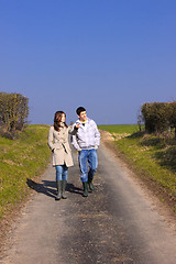 Image showing Couple of young people walking in the campaign in spring