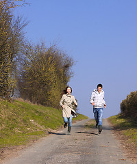 Image showing Couple of young people walking in the campaign in spring