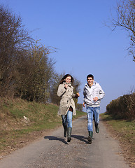 Image showing Couple of young people walking in the campaign in spring