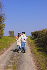 Image showing Couple of young people walking in the campaign in spring