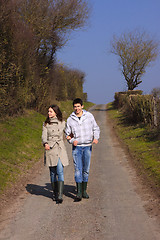 Image showing Couple of young people walking in the campaign in spring