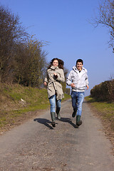 Image showing Couple of young people walking in the campaign in spring