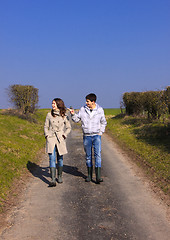 Image showing Couple of young people walking in the campaign in spring