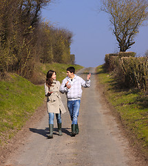 Image showing Couple of young people walking in the campaign in spring