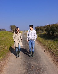 Image showing Couple of young people walking in the campaign in spring