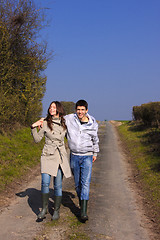 Image showing Couple of young people walking in the campaign in spring