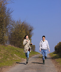 Image showing Couple of young people walking in the campaign in spring