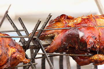 Image showing pig on a spit. Spit roasting is a traditional international method of cooking a whole pig. 