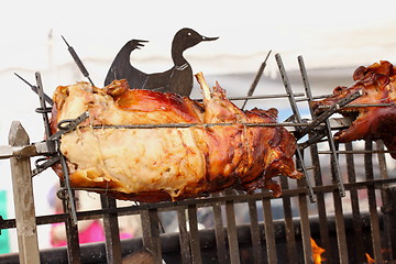 Image showing pig on a spit. Spit roasting is a traditional international method of cooking a whole pig. 