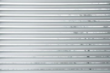 Image showing Semi-closed metallic blinds on a window