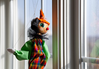 Image showing String puppet gazing outside window in sun