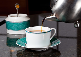 Image showing Tea poured from stainless steel teapot